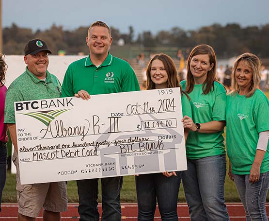 People holding a large check from BTC Bank