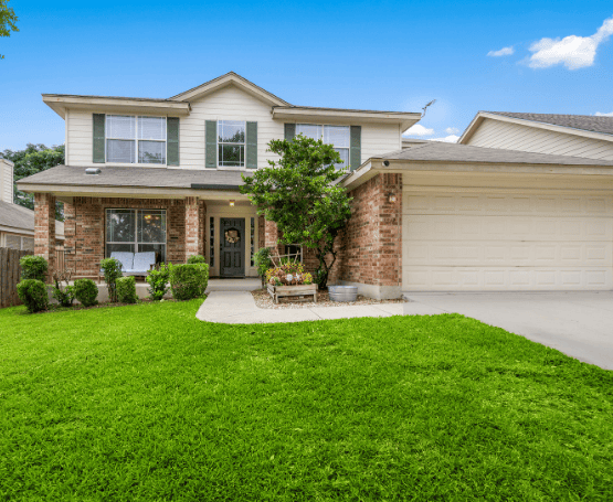 A welcoming, charming home with a freshly cut green lawn and covered porch