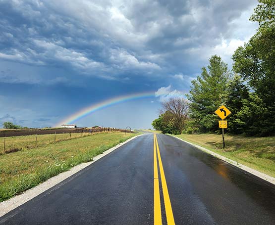 A road with a rainbow at the end of it.