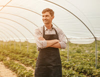 Man in large greenhouse.