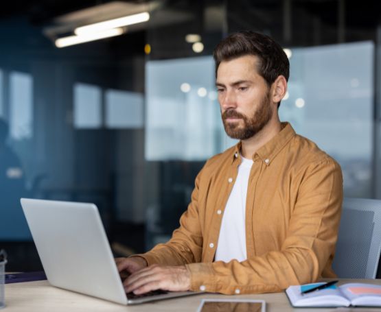 A business man sitting as his desk working on his computer