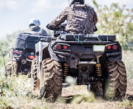 People riding on 4-wheelers in a field