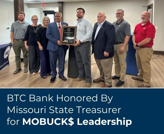 A smiling group of BTC Bank employees being presented with an award from Missouri State Vivek Malek for leadership in MOBUCK$ program