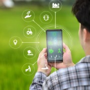 Image of a person holding a smartphone to monitor their modern farm.
