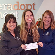 three ladies with a bank donation