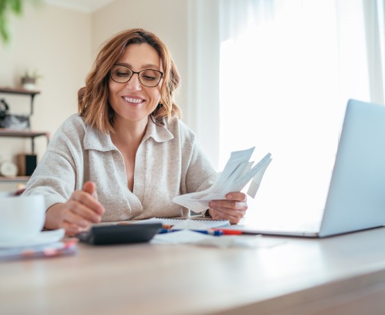 Woman holding receipts and crunching numbers on a calculator