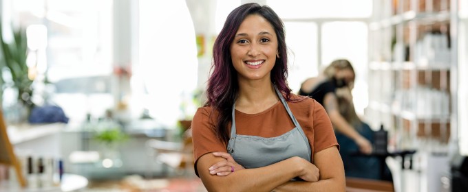 Woman smiles in her small business while customers shop