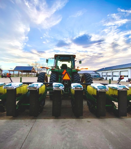 a tractor with blue skies above with the spayer attached to it