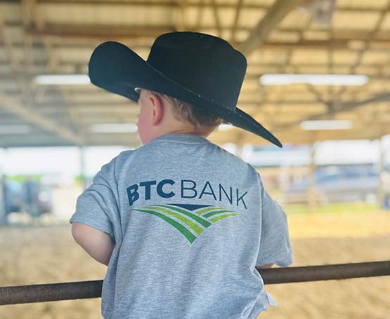 Young kid wearing a cowboy hat in an arena. 