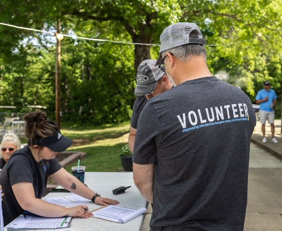 Volunteers standing at a table getting assigned roles