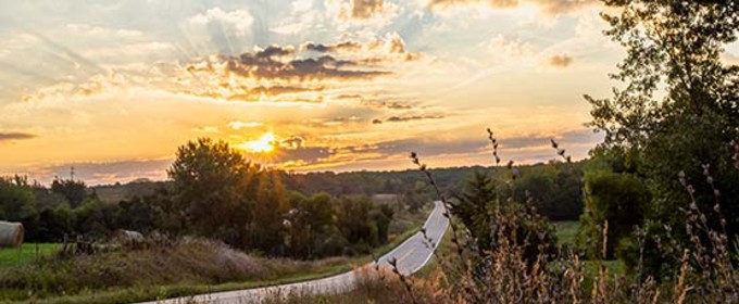 Road stretching into the hills at sunset